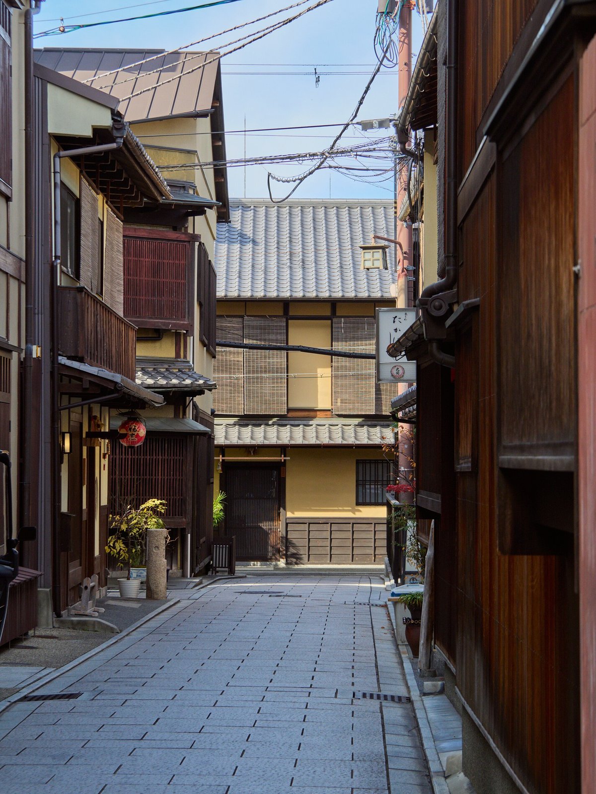 A narrow street of machiya in Gion, Kyoto, between timber facades