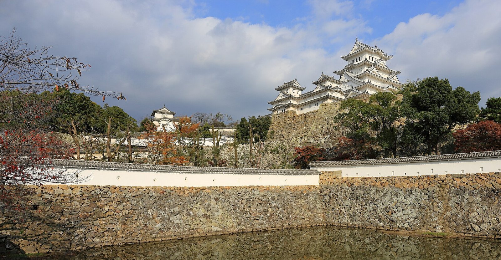 Himeji Castle seen across its moat and stone walls, its keep complex on the hill