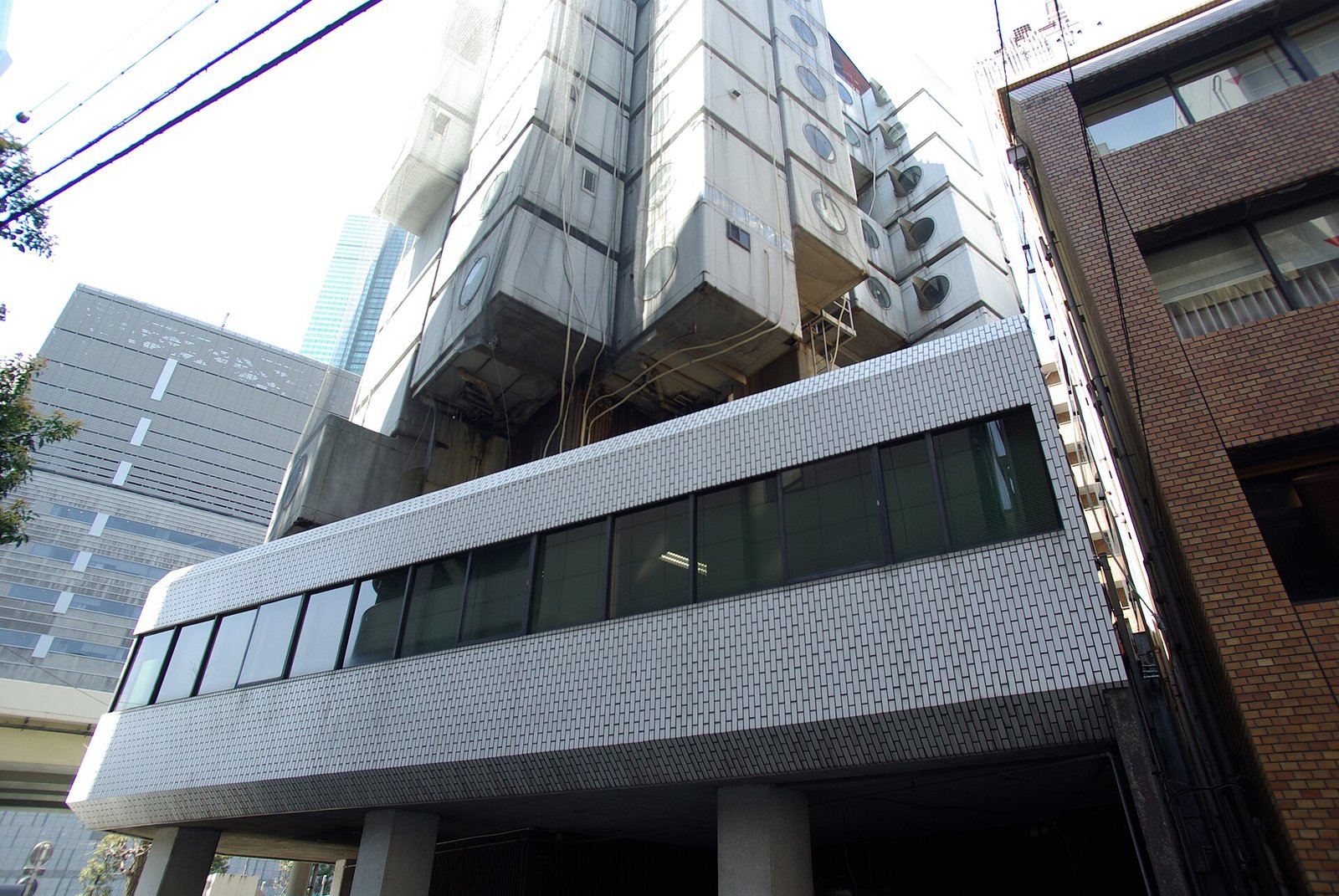 The Nakagin Capsule Tower in Tokyo, its capsules stacked on concrete cores, photographed in 2019