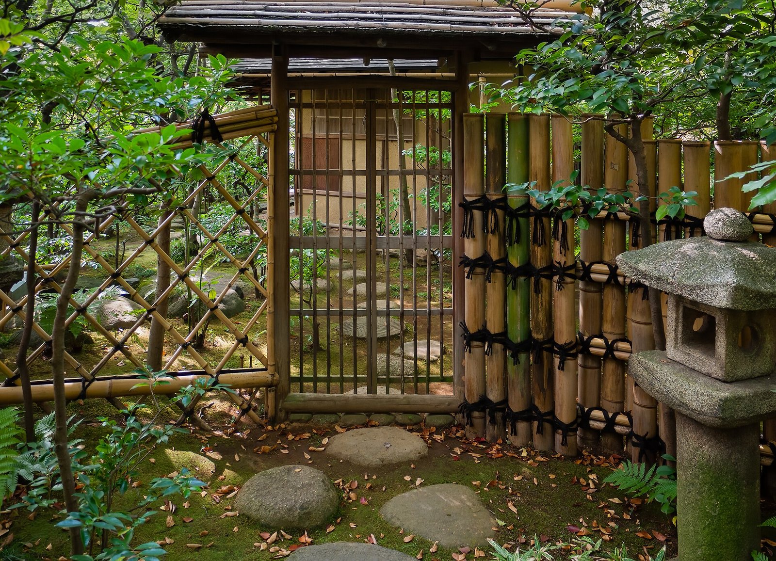 A bamboo fence, stone lantern and stepping stones in the garden at the Nezu Museum, Tokyo