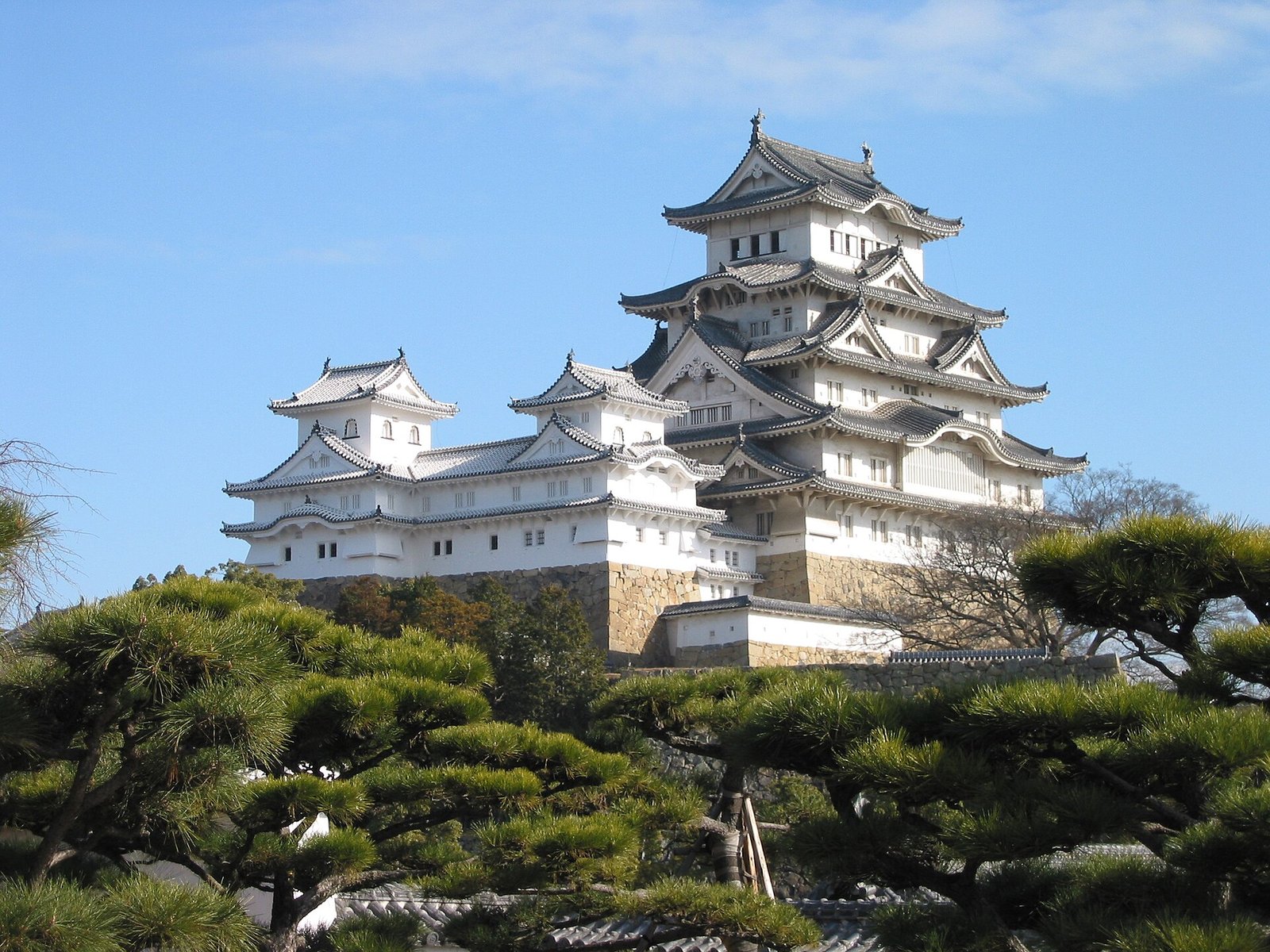The tiered roofs of Himeji Castle, deep eaves over white plaster walls