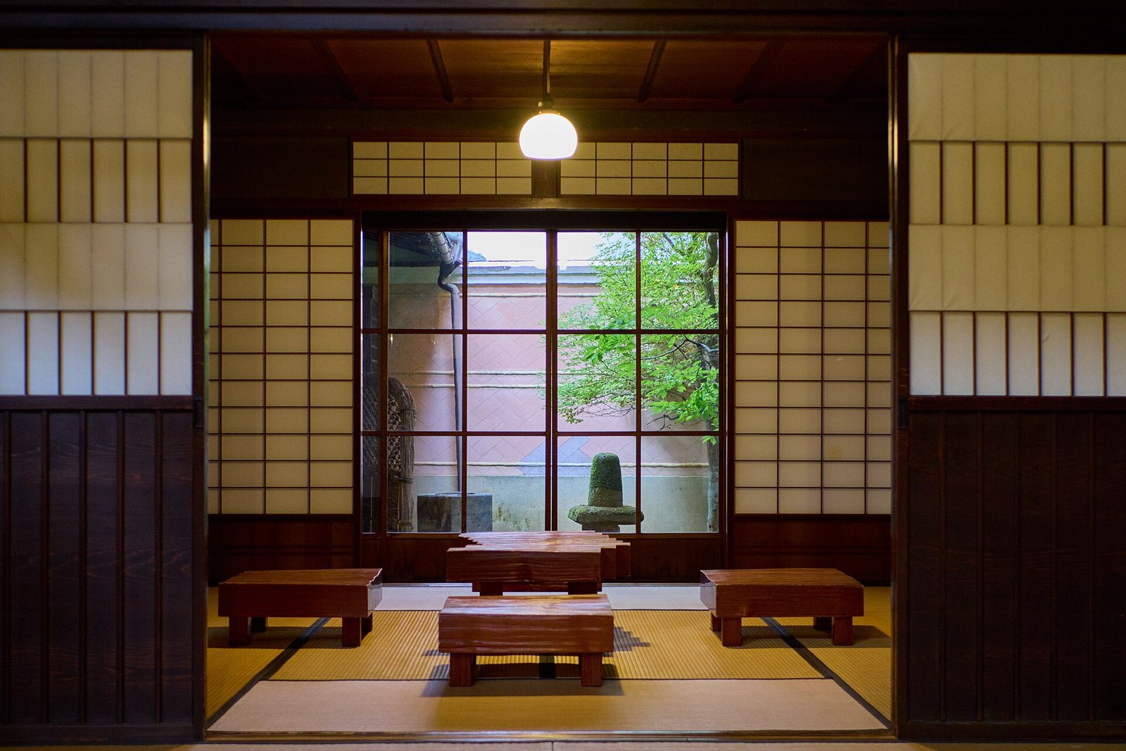 A tatami room opening through shoji screens to a small garden in Takayama