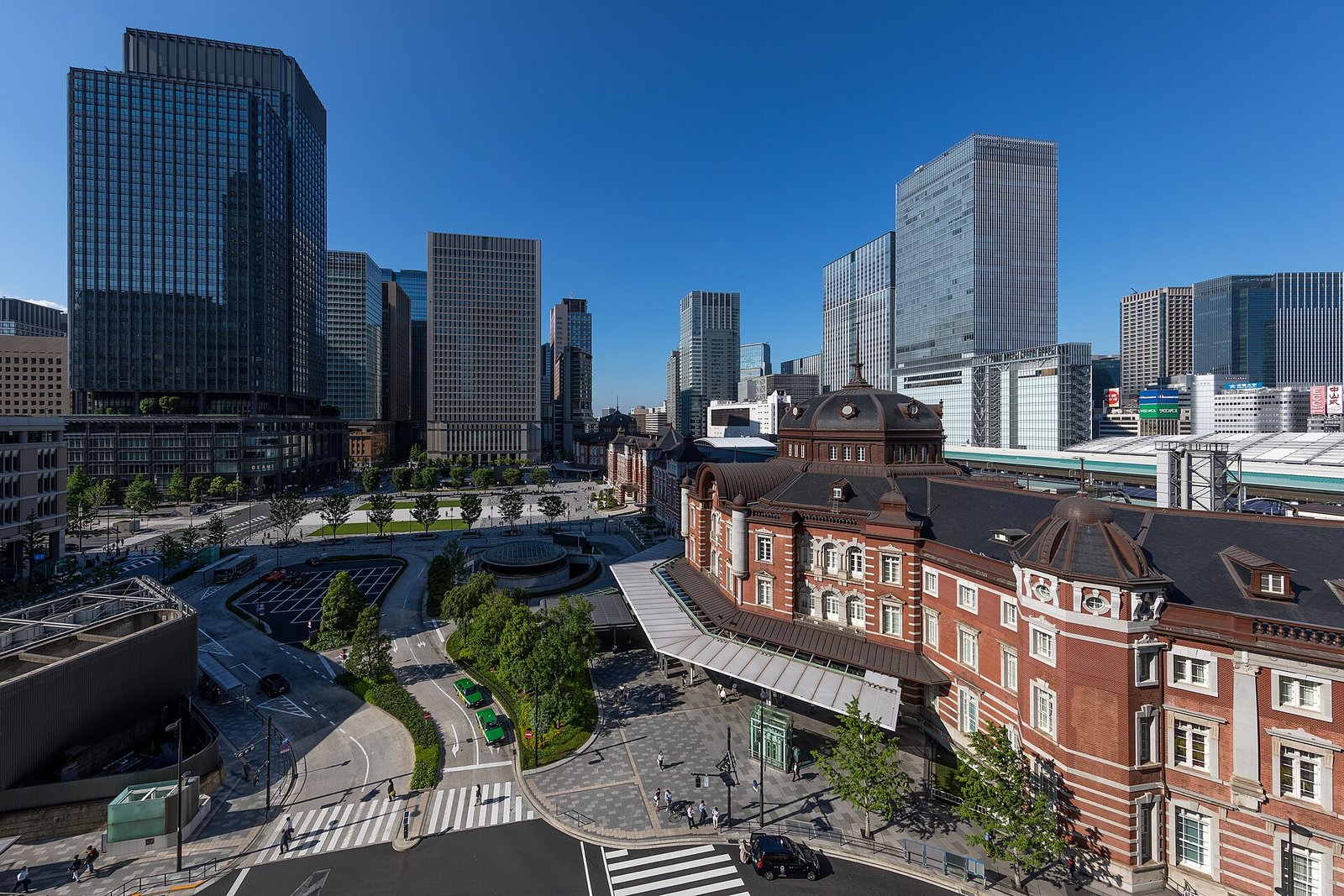 Tokyo Station and its plaza seen from above, the brick station among towers