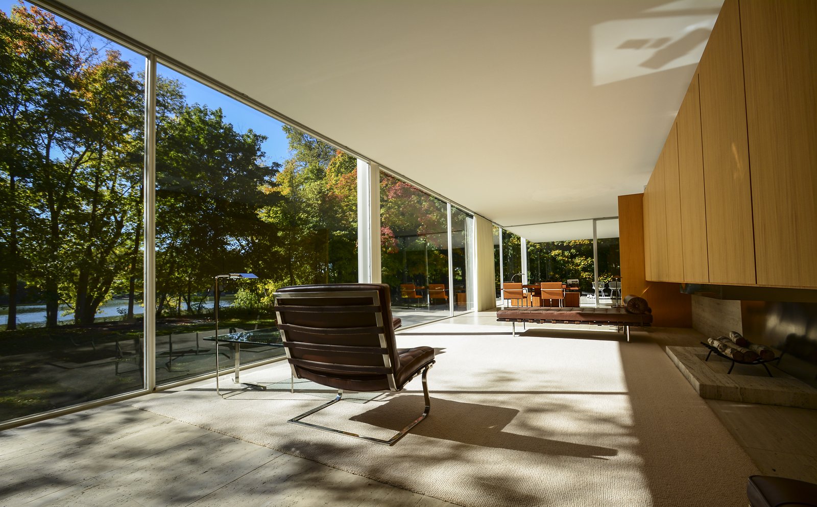 A floor-to-ceiling glass wall opening a living room to the garden