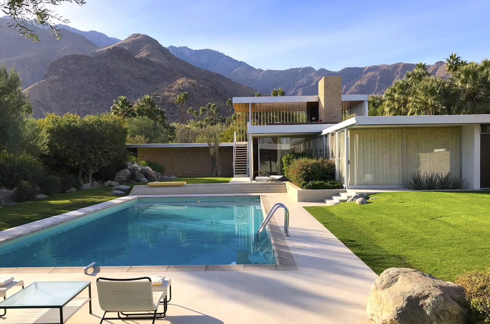 The Kaufmann Desert House in Palm Springs, its flat roof and stone walls against the San Jacinto mountains