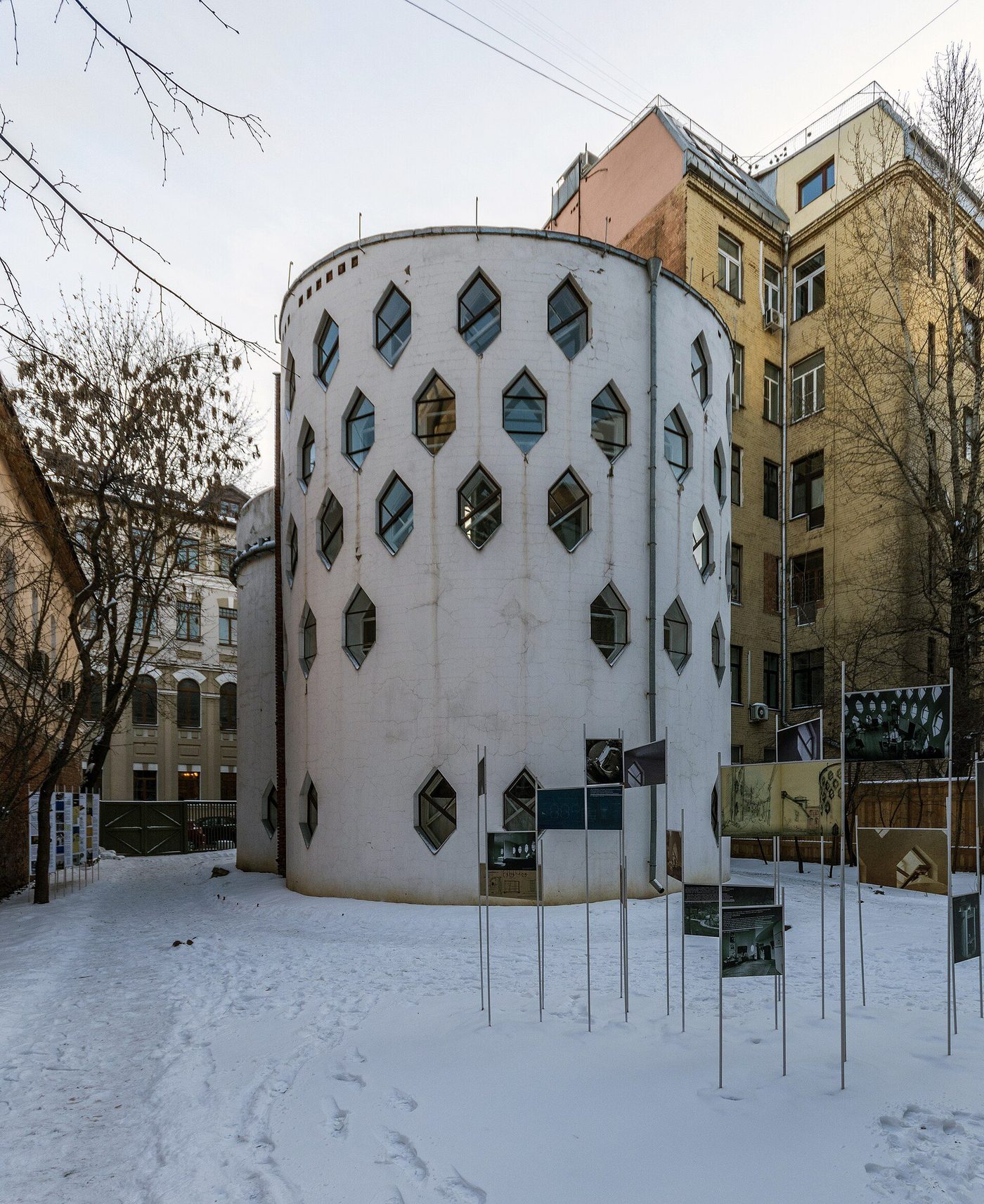 The Melnikov House in Moscow: a white cylinder pierced by hexagonal windows, in snow