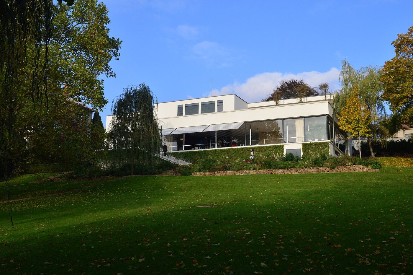 Villa Tugendhat from its garden at Brno: a white horizontal house behind lawns and trees