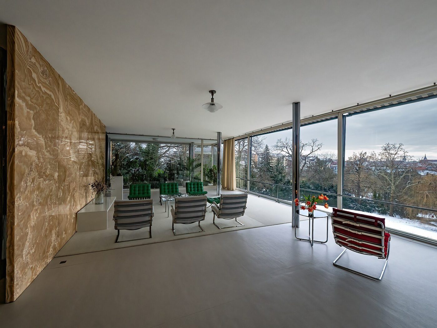 The living space of Villa Tugendhat: onyx wall, chrome columns and a wall of glass to the garden