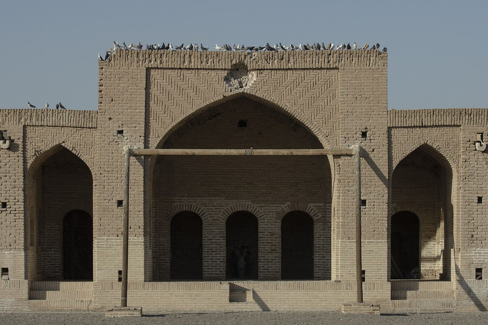 The entrance front of the Deir-e Gachin caravanserai: a plain brick facade with a central arched portal