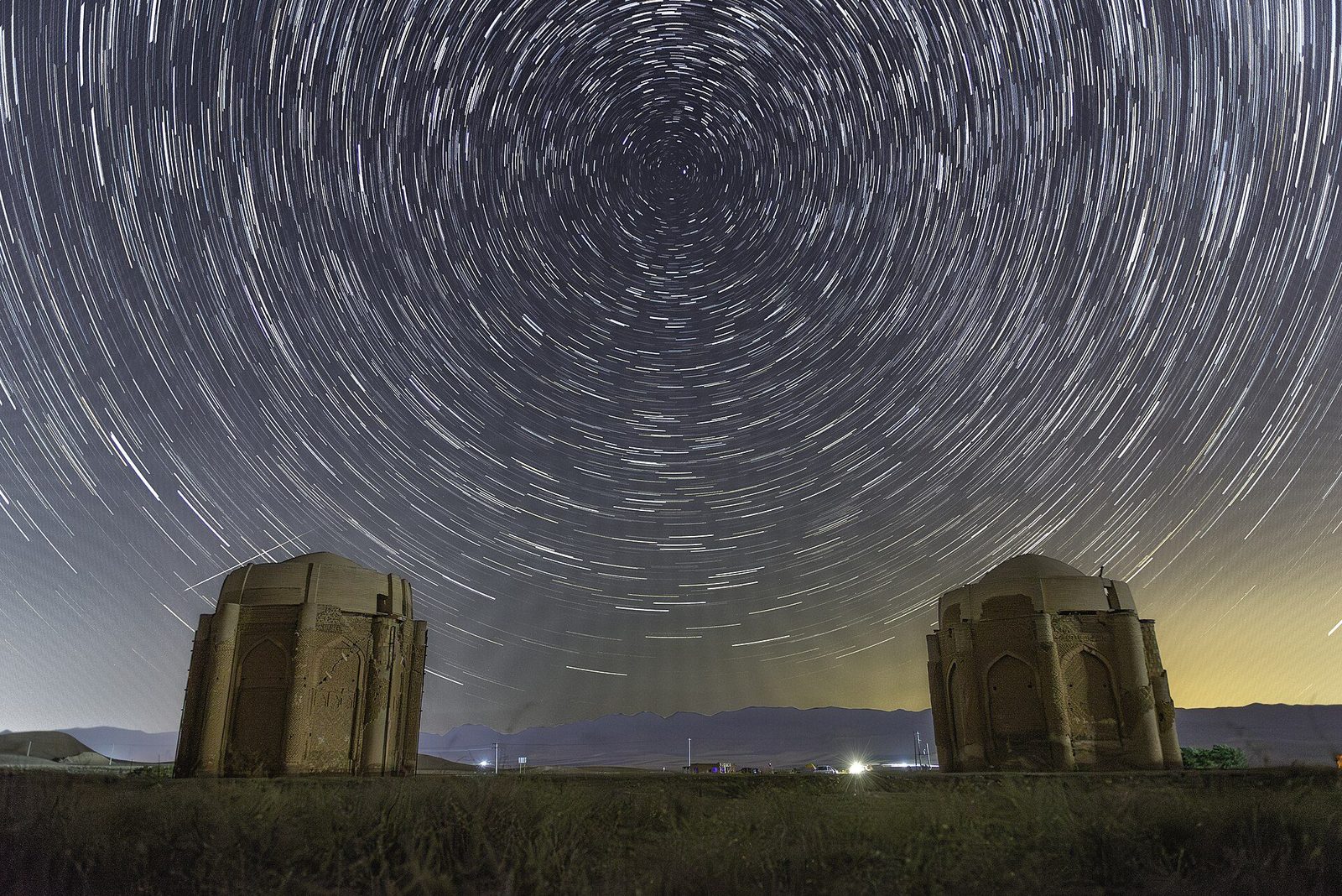 The two Kharraqan tomb towers photographed at night, under circling star trails