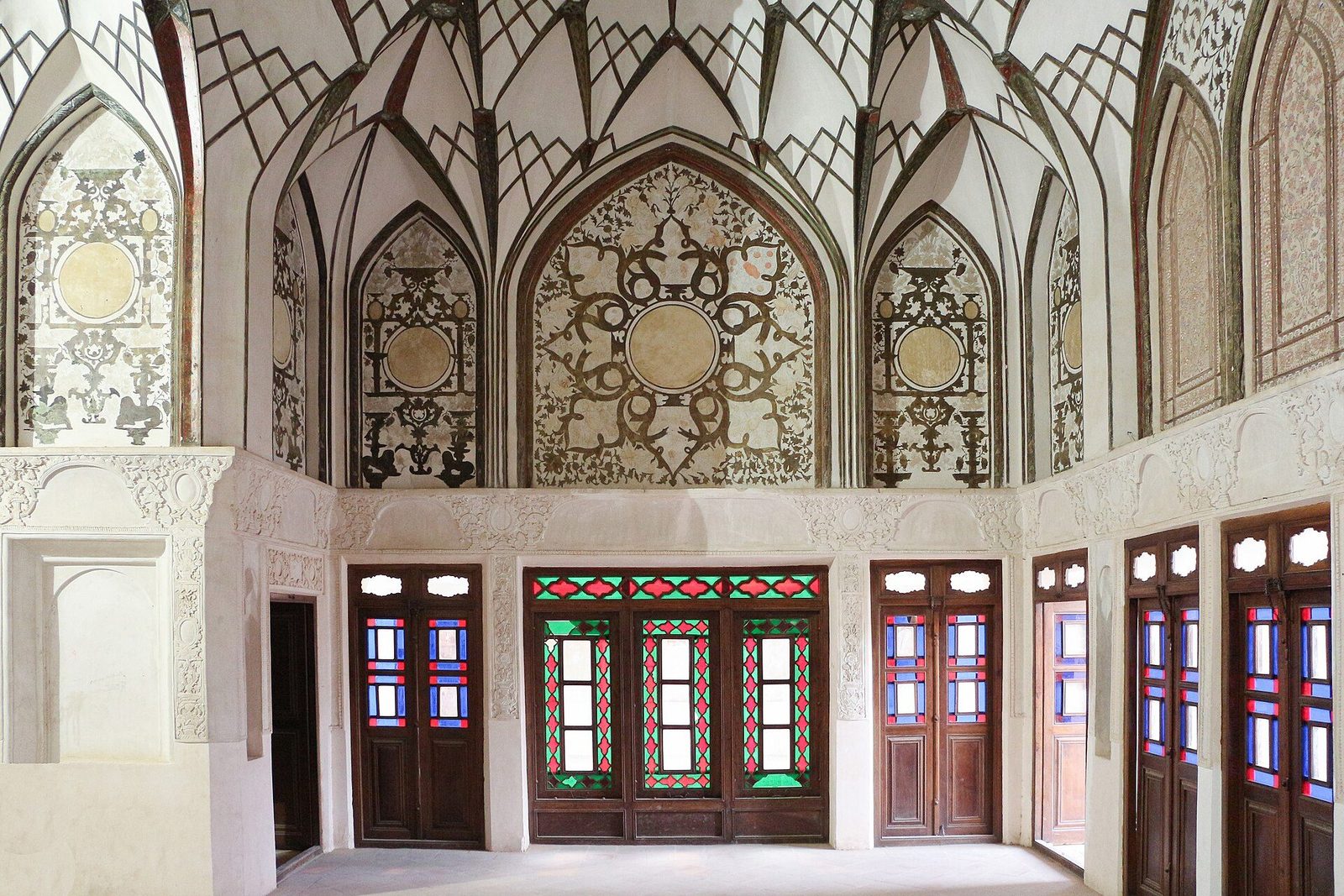 The main hall of the Tabatabaei House in Kashan: stucco vaulting, carved plaster and stained-glass doors