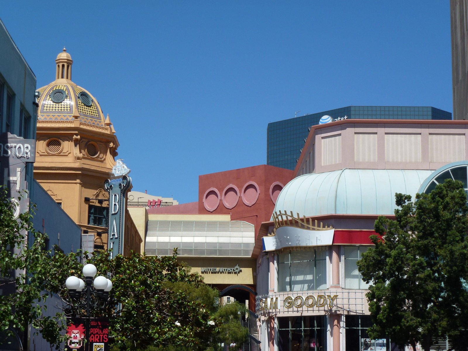 The colourful facades of Horton Plaza in San Diego, with a golden dome, pink walls and a pale blue domed roof.