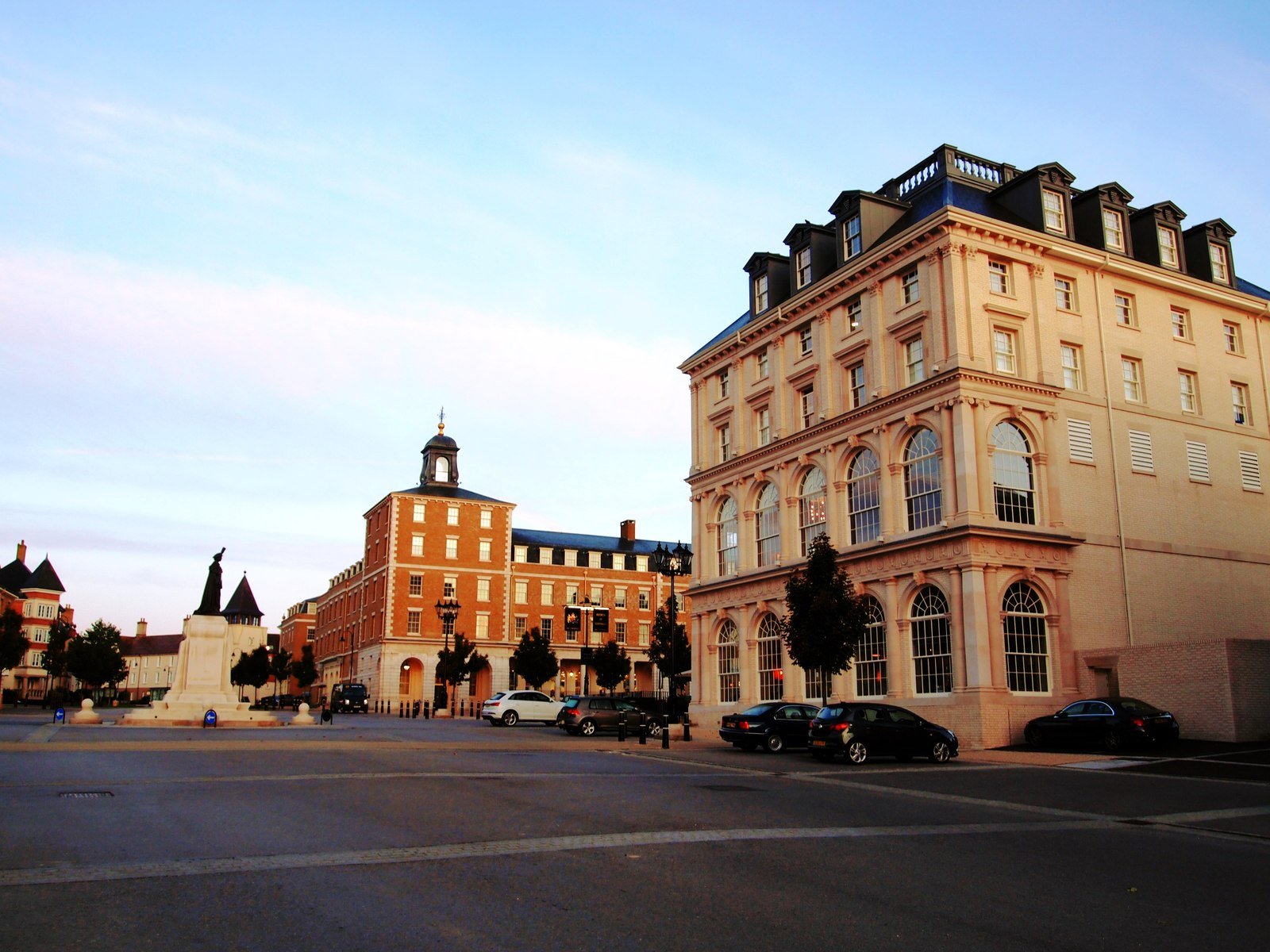 Queen Mother Square in Poundbury, with classical stone facades, arched windows and a statue in the square.