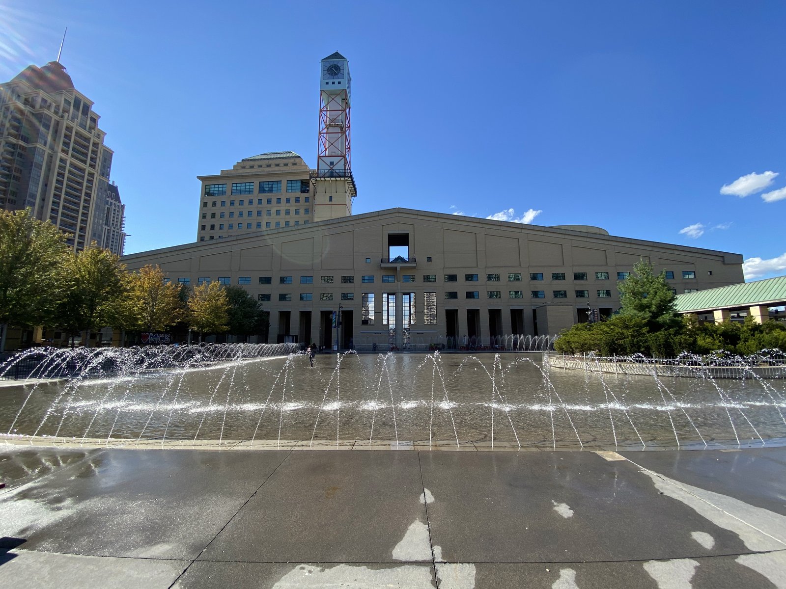 Mississauga City Hall in Canada seen across a fountain plaza, its main hall block and tall clock tower behind it.