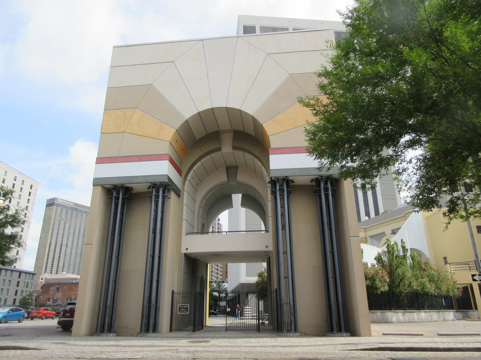 The entrance arch of Piazza d'Italia in New Orleans, with tall fluted columns and stepped, colourful stonework.