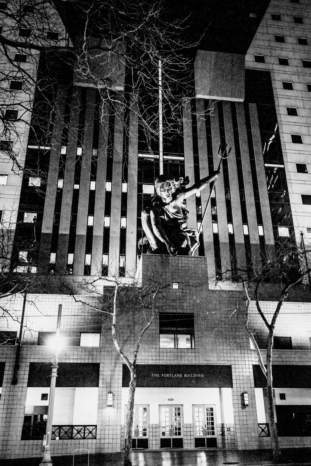 The Portland Building in Portland, Oregon, photographed at night, its tiled facade and the Portlandia statue lit against the dark sky.