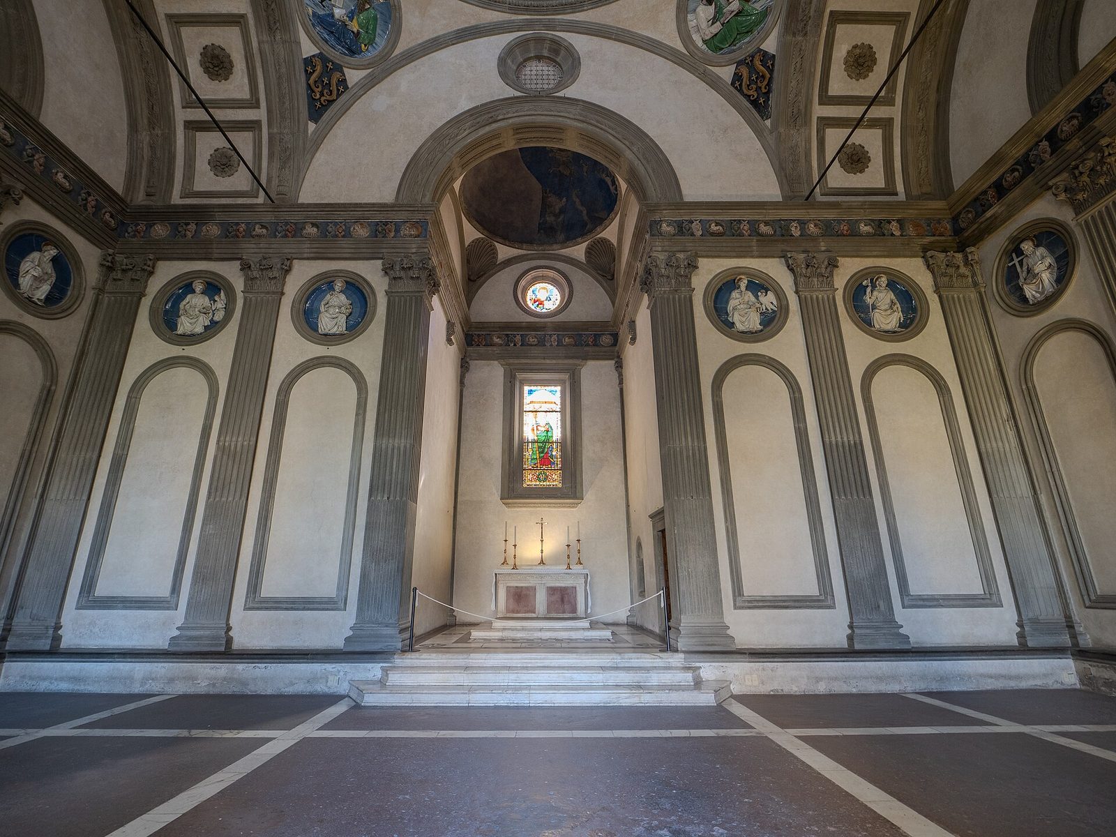 The interior of the Pazzi Chapel in Florence, grey pilasters on white plaster under a small dome