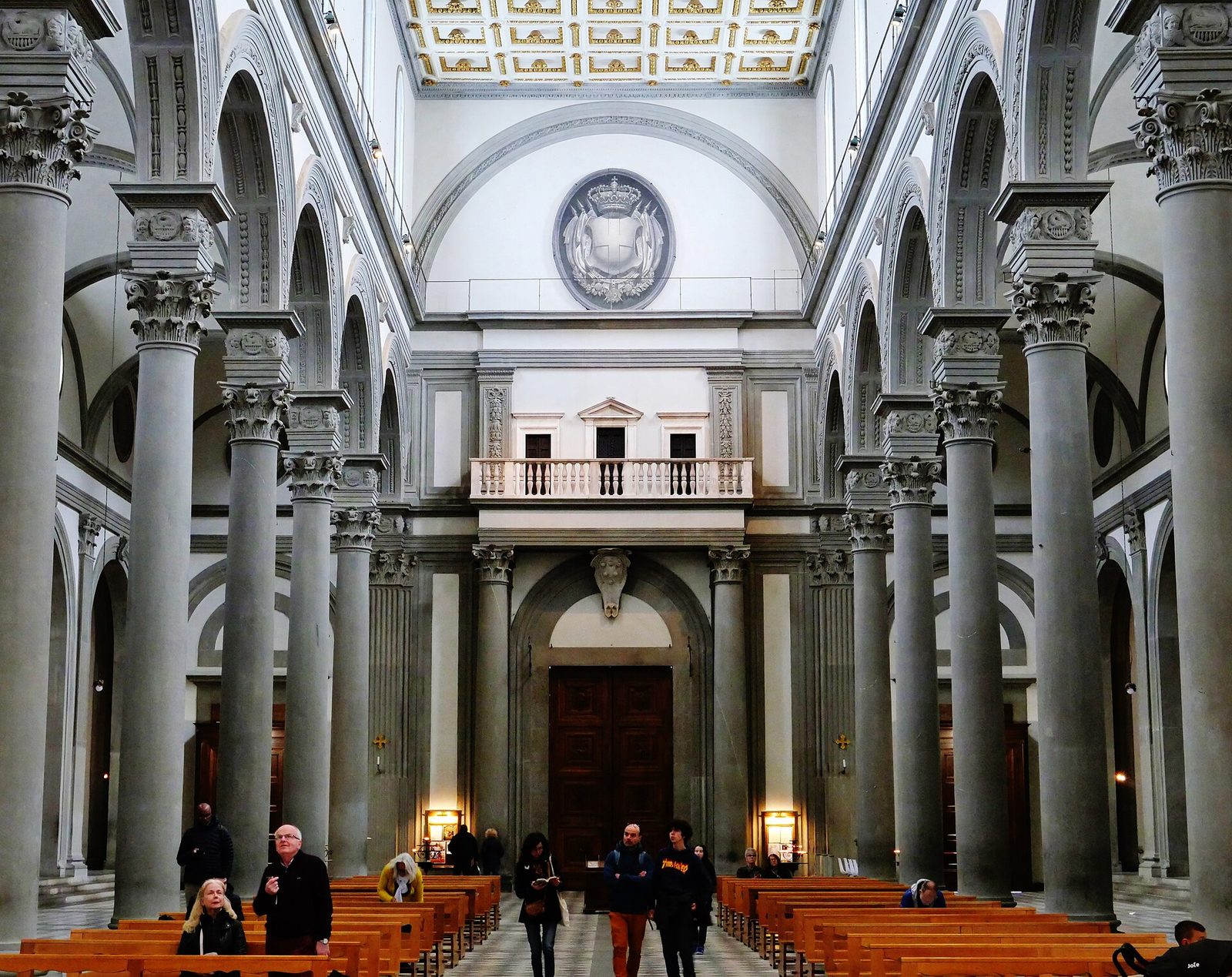 The nave of San Lorenzo in Florence, grey stone columns carrying round arches