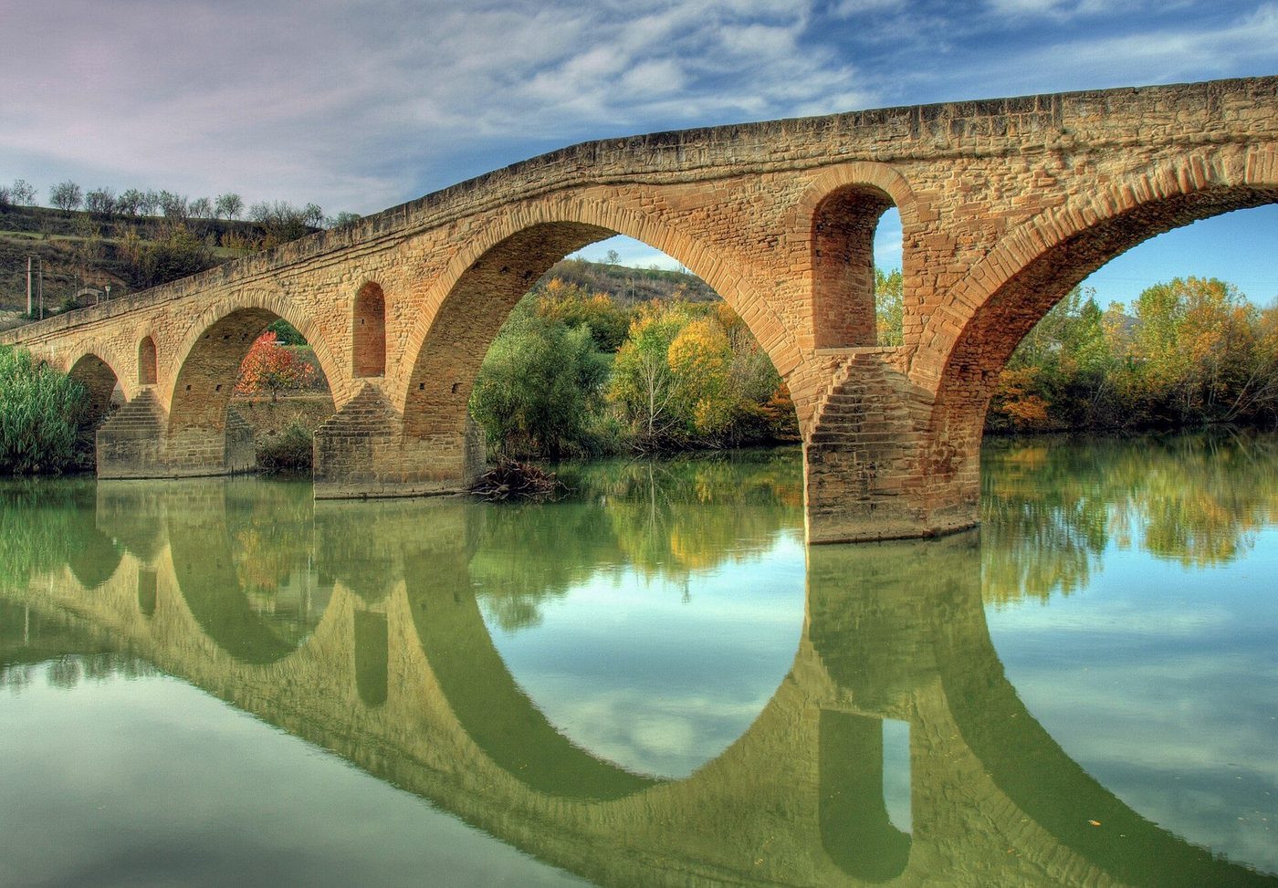 The Romanesque pilgrims' bridge at Puente la Reina reflected in the River Arga