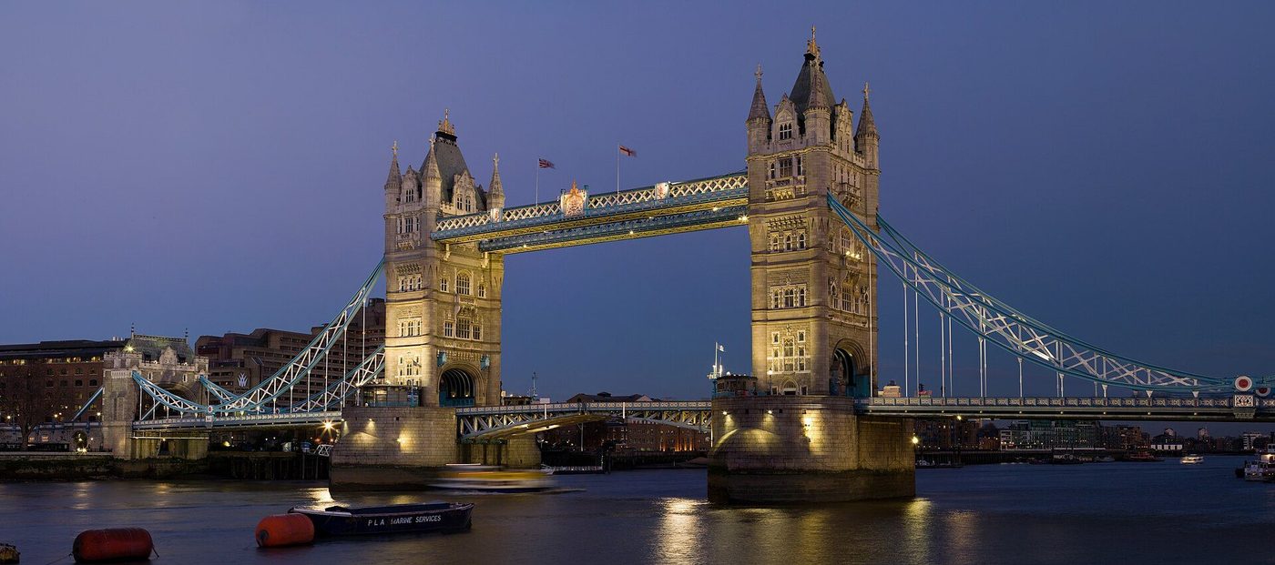 Tower Bridge at dusk: the twin Gothic towers and high-level walkways lit over the Thames