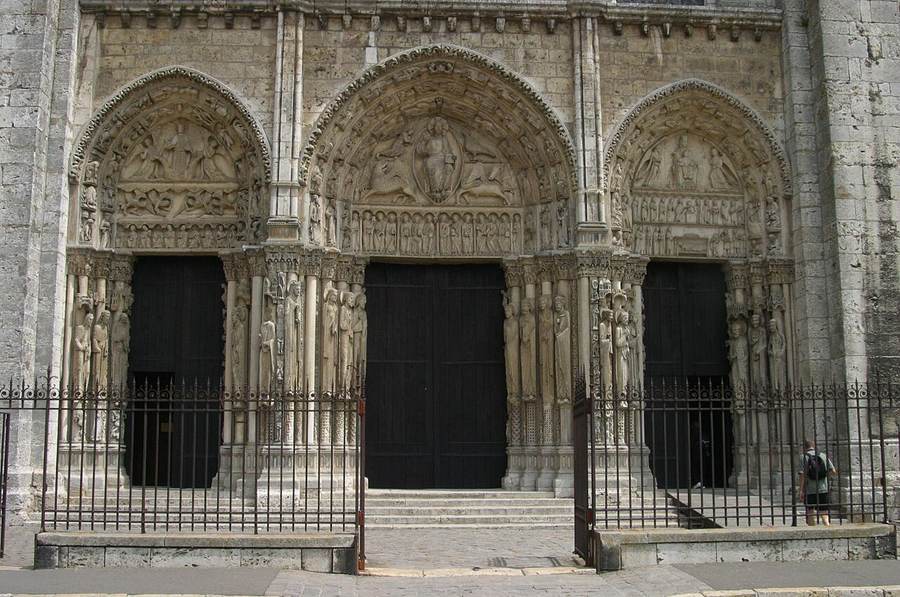 West facade of Chartres Cathedral with two contrasting spires, three sculpted portals and rose window