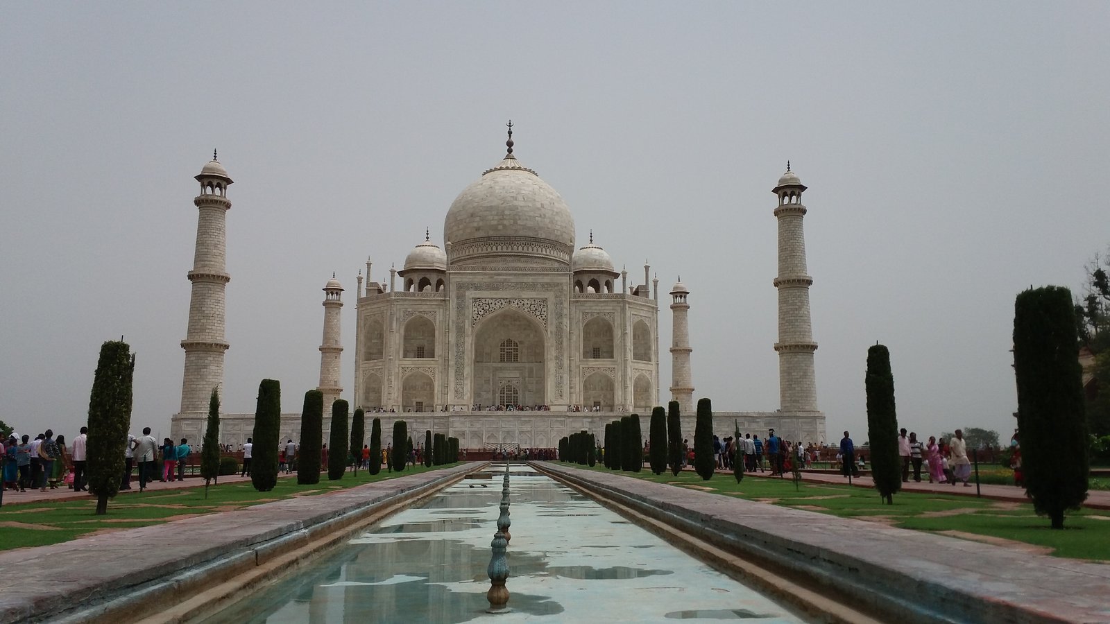 The Taj Mahal reflected in its garden pool at Agra, its white marble dome and minarets framed by the charbagh