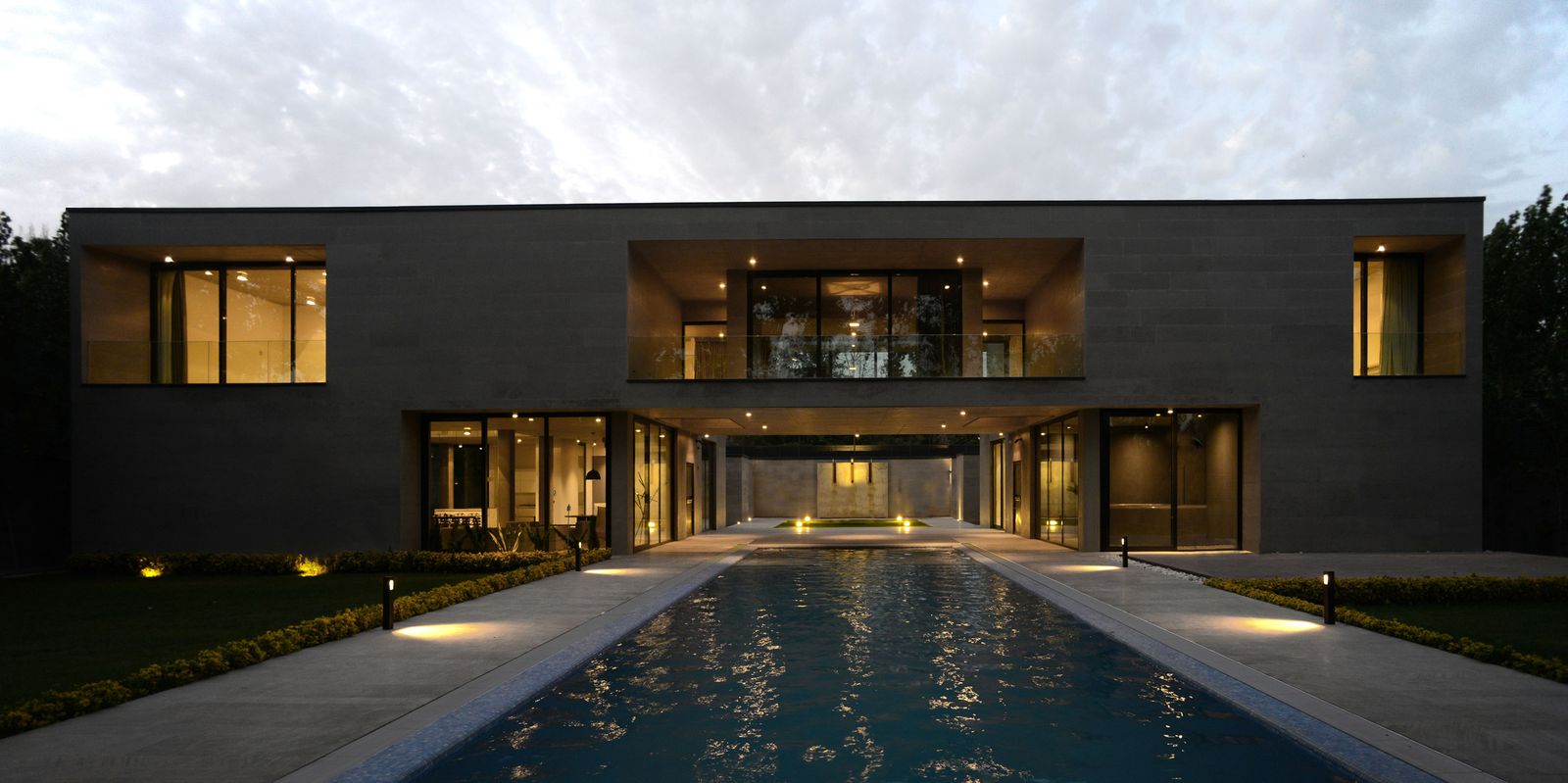 Villa Safadasht at dusk — the Esparakhon stone facade and the pool on the garden axis